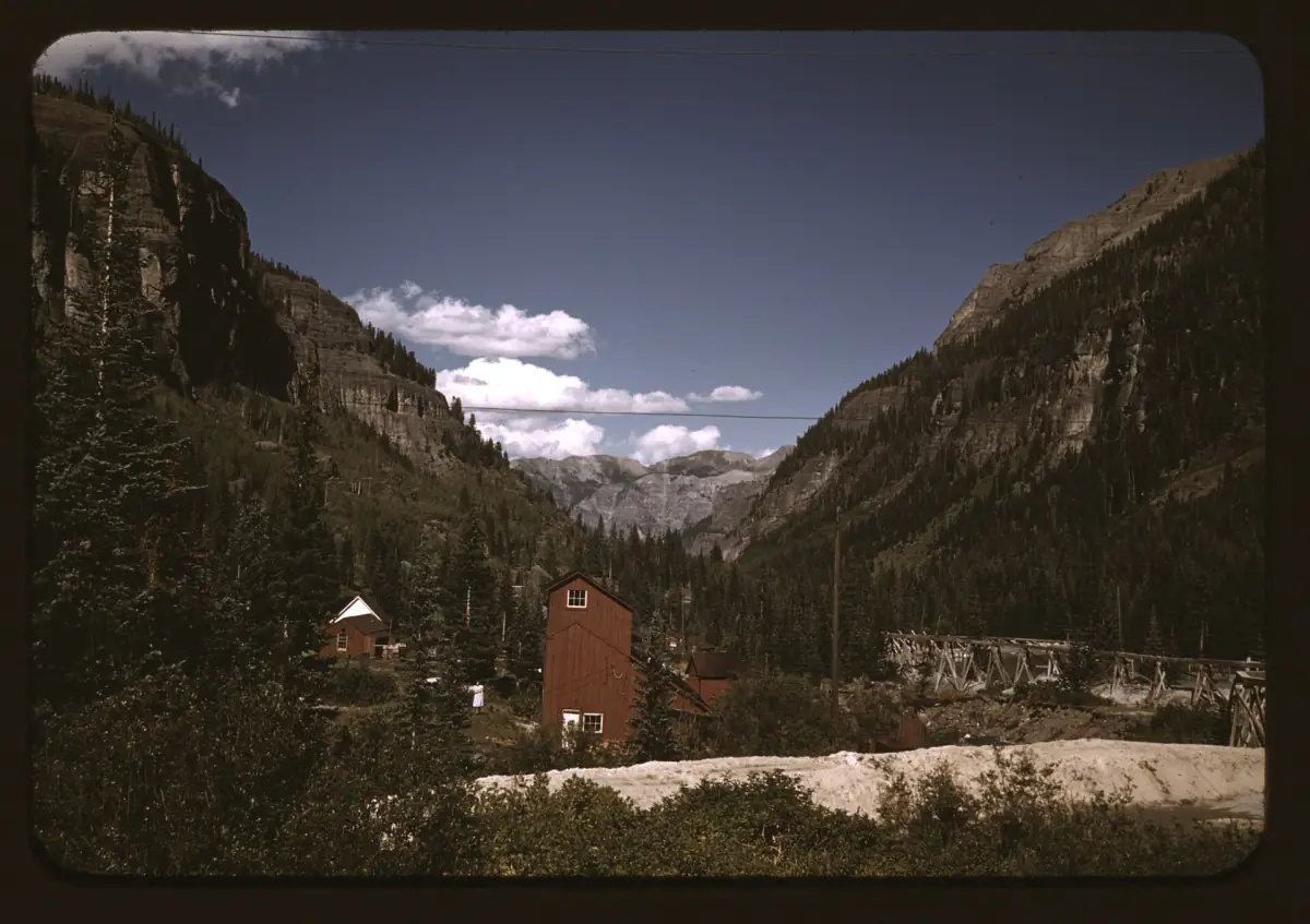 Looking down the steep-walled valley toward Ouray from the Camp Bird Mine, with mine buildings in the foreground, in a color photo by Russell Lee from October 1940.