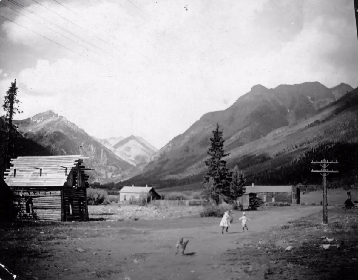 Two children and a dog in Capitol City (Galena City), Hinsdale County, in a photograph from about 1880-1900.
