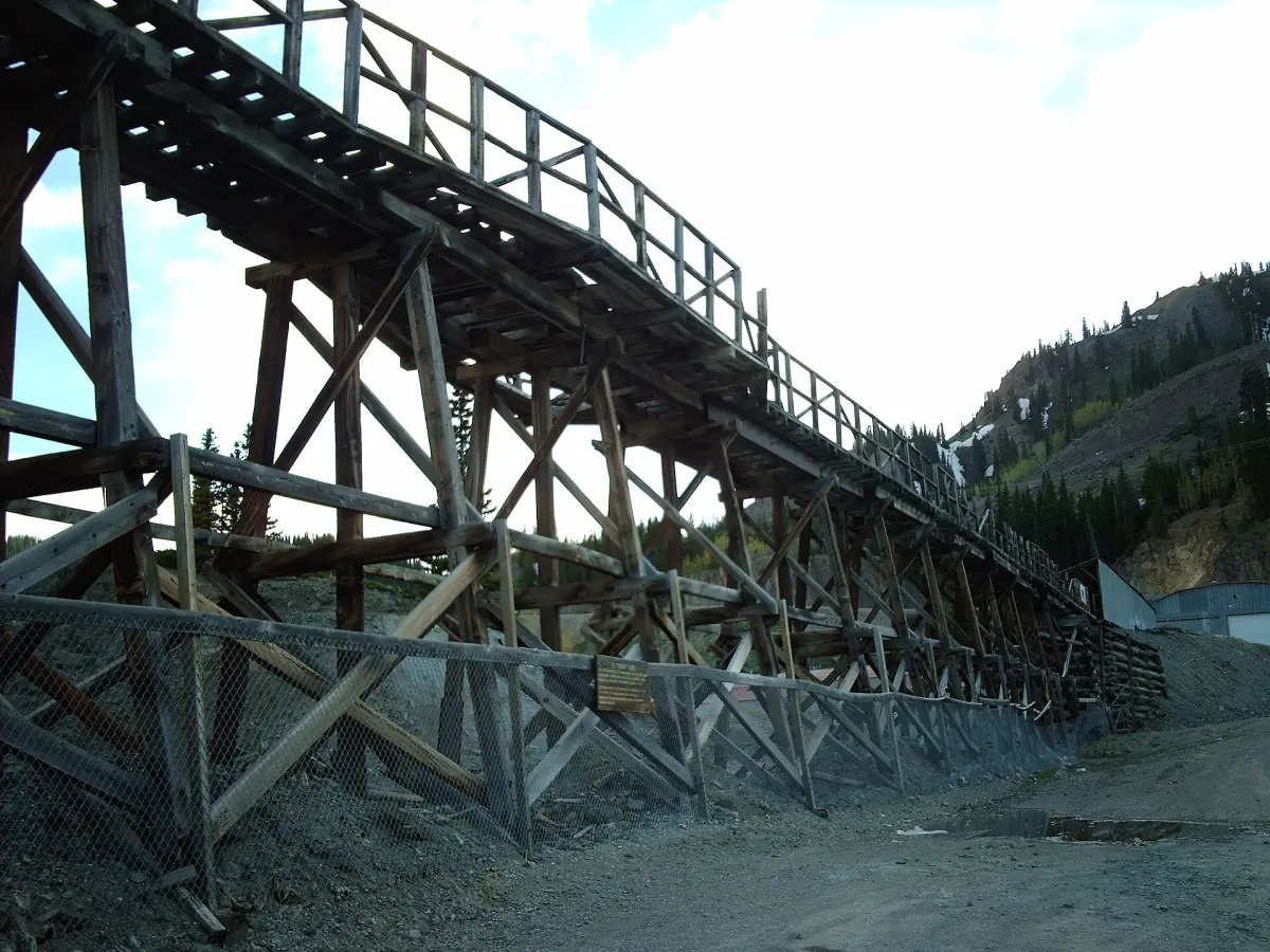 The wooden Idarado Mine trestle beside a gravel lot, photographed in June 2006.